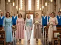 Des femmes en robes pastel et hommes en gilets bleus, une inspiration pour comment s'habiller pour une communion.