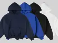 Quatre sweats à capuche pour femme : bleu marine, bleu vif, noir et blanc. Parfait pour une tenue décontractée.