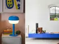 Lampe et meuble bas dans un éclatant couleur bleu cobalt. Une lampe design éclaire une table de chevet, tandis qu'un meuble bas expose des objets décoratifs.