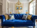 Canapé bleu roi somptueux, rehaussé de coussins dorés et bleus. Quelle couleur associer au bleu roi ? L'or, pour une touche royale.