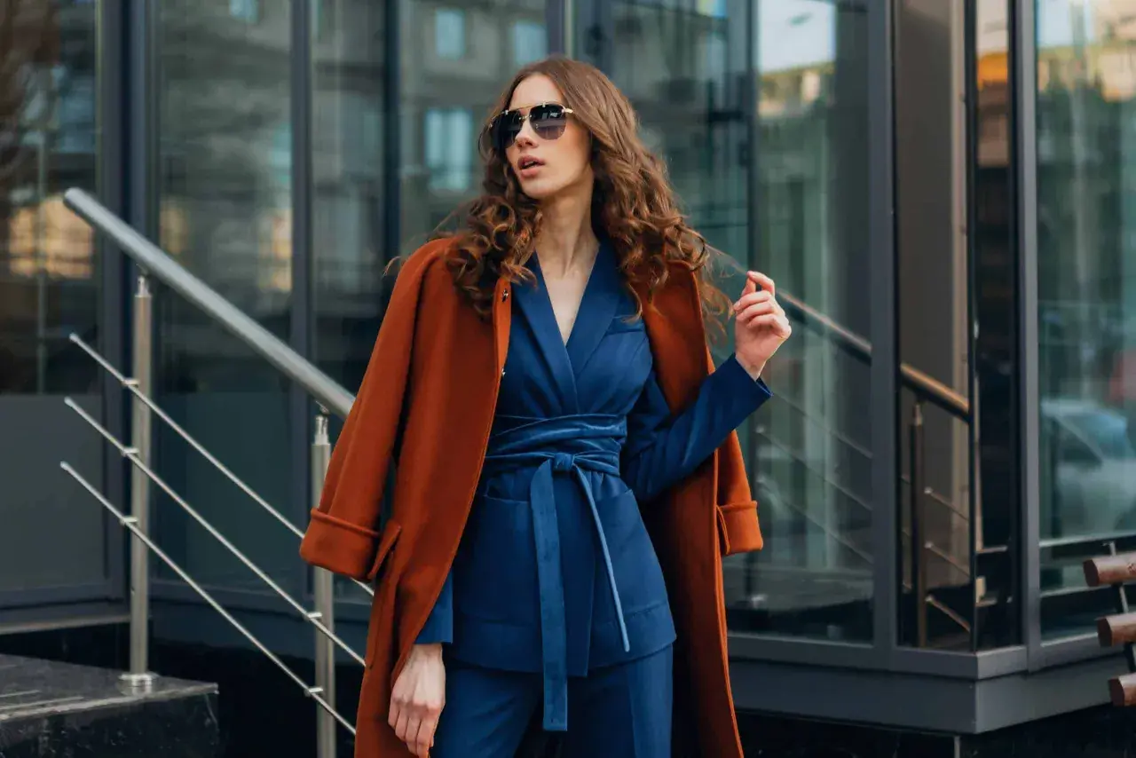 Quelle veste avec robe bleu marine pour mariage ? Un manteau rouille chic complète cette tenue élégante.
