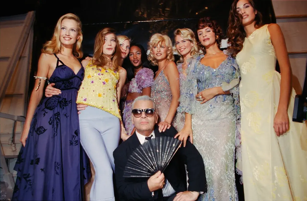 Karl Lagerfeld et des mannequins posent, un éventail à la main, dans un style année 90.