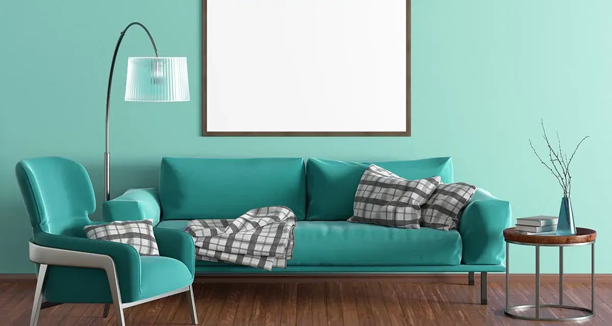 Un salon moderne aux murs bleu turquoise. Un fauteuil et un canapé assortis, avec des coussins à carreaux. Quelle couleur va avec le bleu turquoise vêtement ? Le gris et le bois.