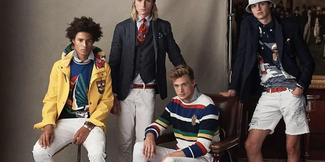 Quatre jeunes hommes posent dans un style preppy, arborant des vestes colorées, des pulls rayés et des pantalons blancs.
