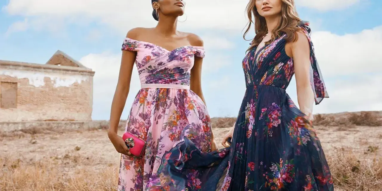 Deux femmes portent des robes fleuries, une rose et une bleu nuit, évoquant la couleur demoiselle d'honneur parfaite pour un mariage champêtre.