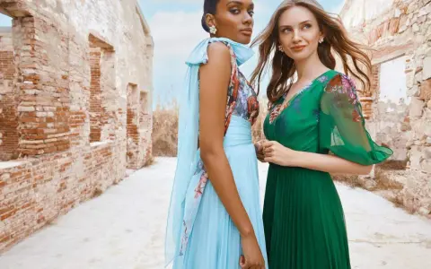 Deux femmes portent des robes élégantes, parfaites pour une tenue mariage avril. L'une est en bleu ciel plissé, l'autre en vert émeraude.