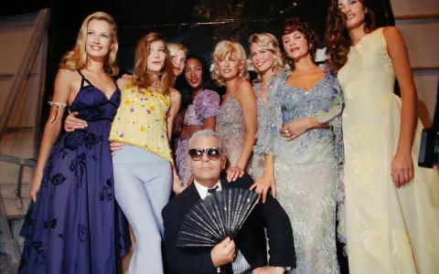 Karl Lagerfeld et des mannequins posent pour une soirée année 90 comment s'habiller. Tenues scintillantes et robes fluides.