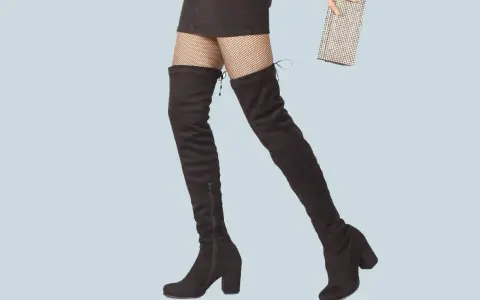 Jambes portant des cuissardes noires et un mini-short, prêtes pour une soirée chic avec une pochette scintillante.