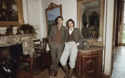 Un couple élégant dans un salon cossu, évoquant un style "old money" intemporel.