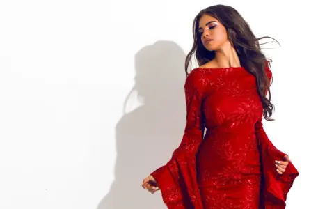 Une femme porte une robe rouge scintillante avec des manches évasées. Quelle veste avec une robe rouge serait parfaite pour compléter ce look ?