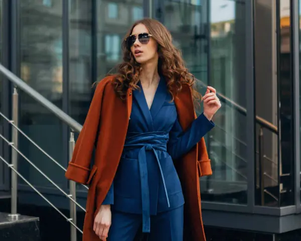 Quelle veste avec robe bleu marine pour mariage ? Un manteau rouille chic complète cette tenue élégante.