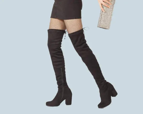 Jambes portant des cuissardes noires et un mini-short, prêtes pour une soirée chic avec une pochette scintillante.