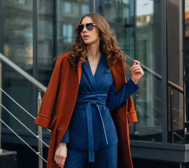 Quelle veste avec robe bleu marine pour mariage ? Un manteau rouille chic complète cette tenue élégante.