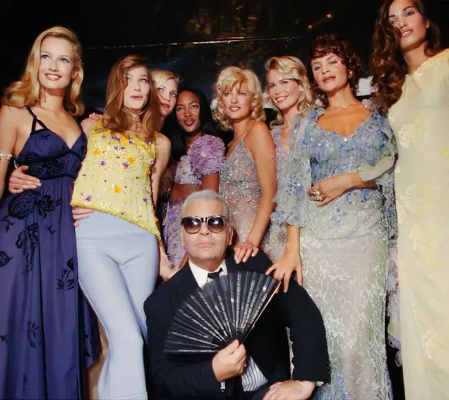Karl Lagerfeld et des mannequins posent, un éventail à la main, dans un style année 90.