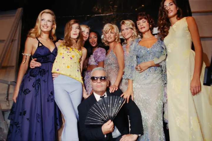 Karl Lagerfeld et des mannequins posent, un éventail à la main, dans un style année 90.