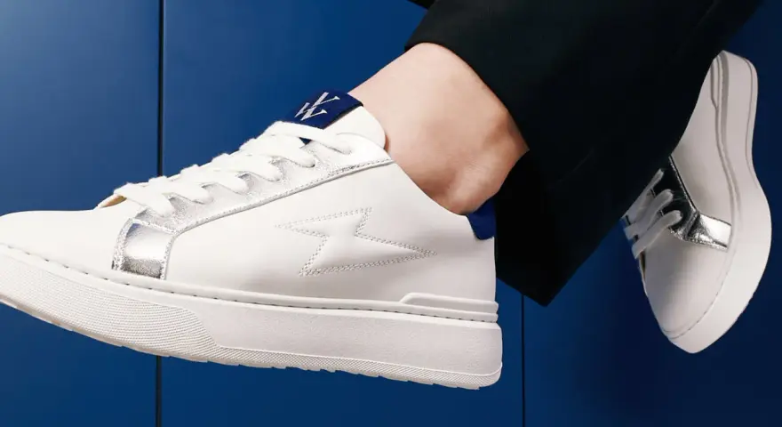 Une tenue chic avec une basket blanche femme, ornée d'éclairs argentés et d'un logo bleu. Parfait pour un look moderne.