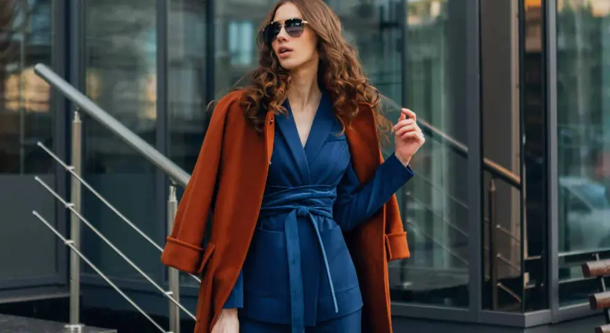 Quelle veste avec robe bleu marine pour mariage ? Un manteau rouille chic complète cette tenue élégante.
