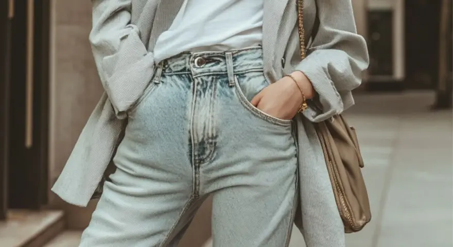 Un blazer gris rayé sur un t-shirt blanc et un **outfit jean bleu** décontracté, avec un sac bandoulière kaki.