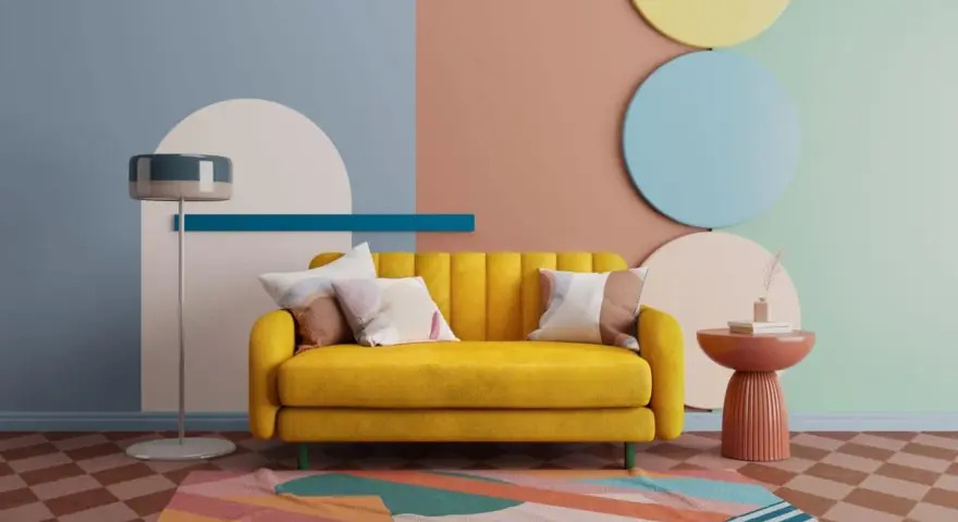 Canapé jaune vif, avec des coussins aux motifs abstraits. Le mur est décoré de formes géométriques et de couleurs douces, dont une touche de couleur complémentaire rouge sur la table d'appoint.