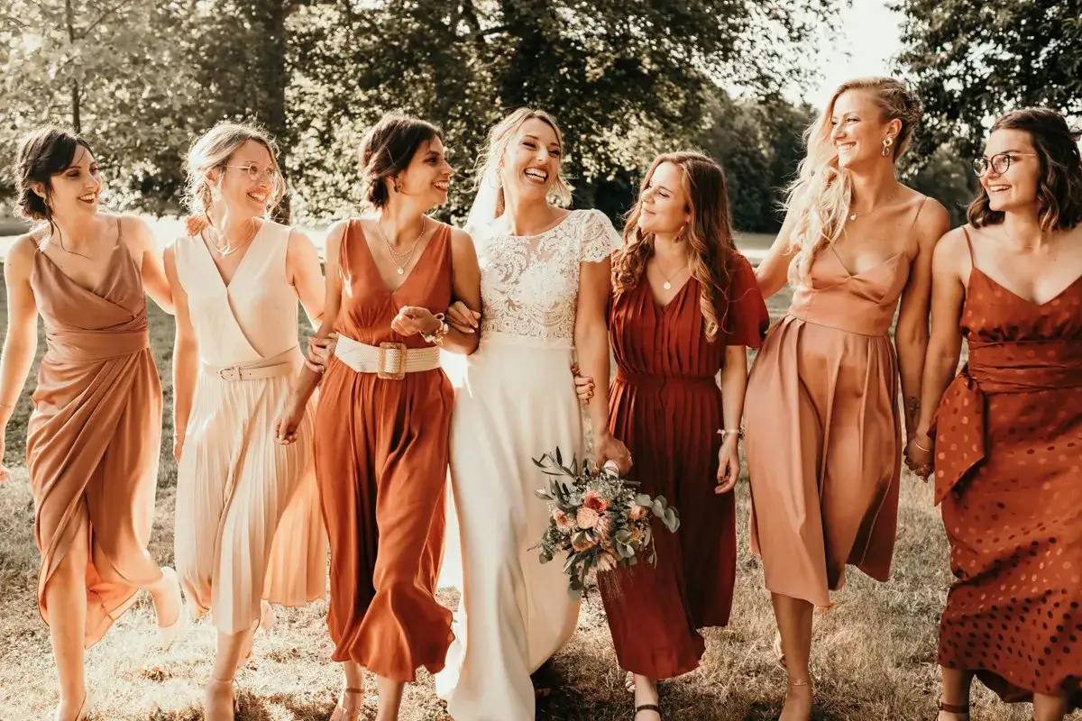 La mari&eacute;e et ses demoiselles d'honneur arborent des robes aux tons chauds, cr&eacute;ant une harmonie de couleur demoiselle d'honneur parfaite pour un mariage d'automne.