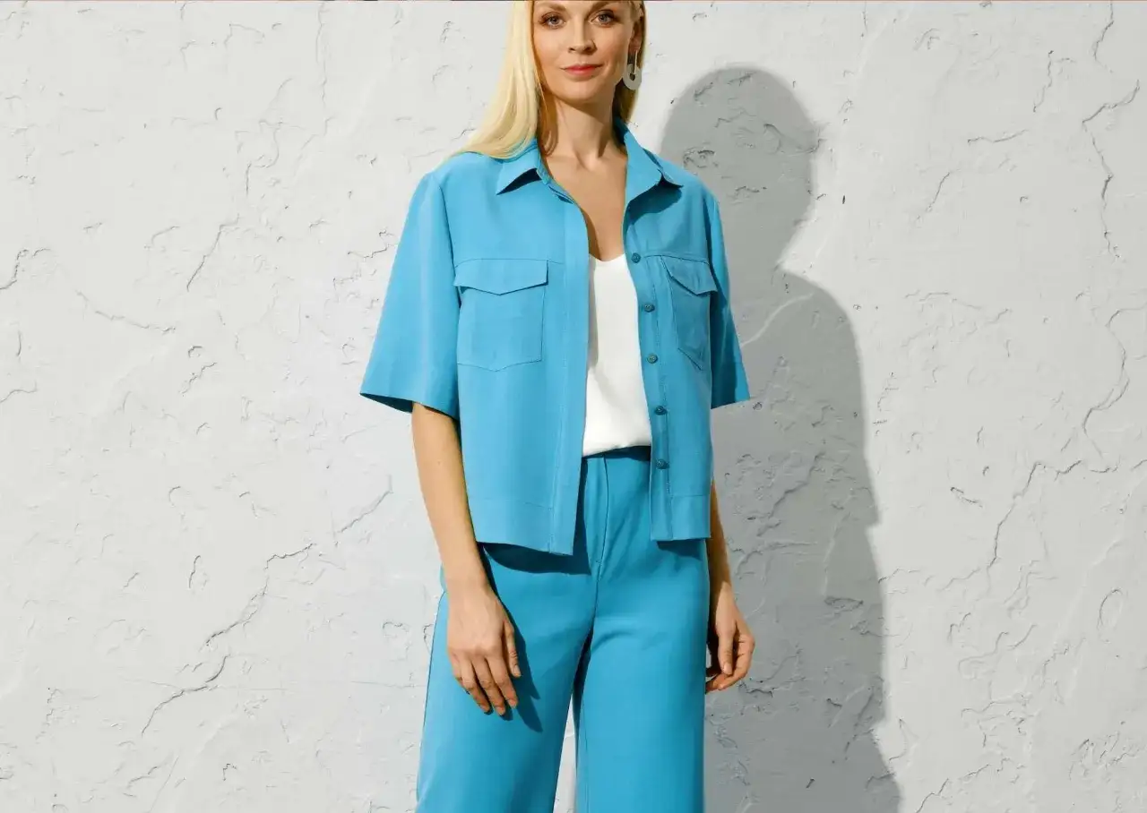 Une femme porte un ensemble bleu turquoise. Quelle couleur va avec le bleu turquoise v&ecirc;tement ? Le blanc est une option parfaite.