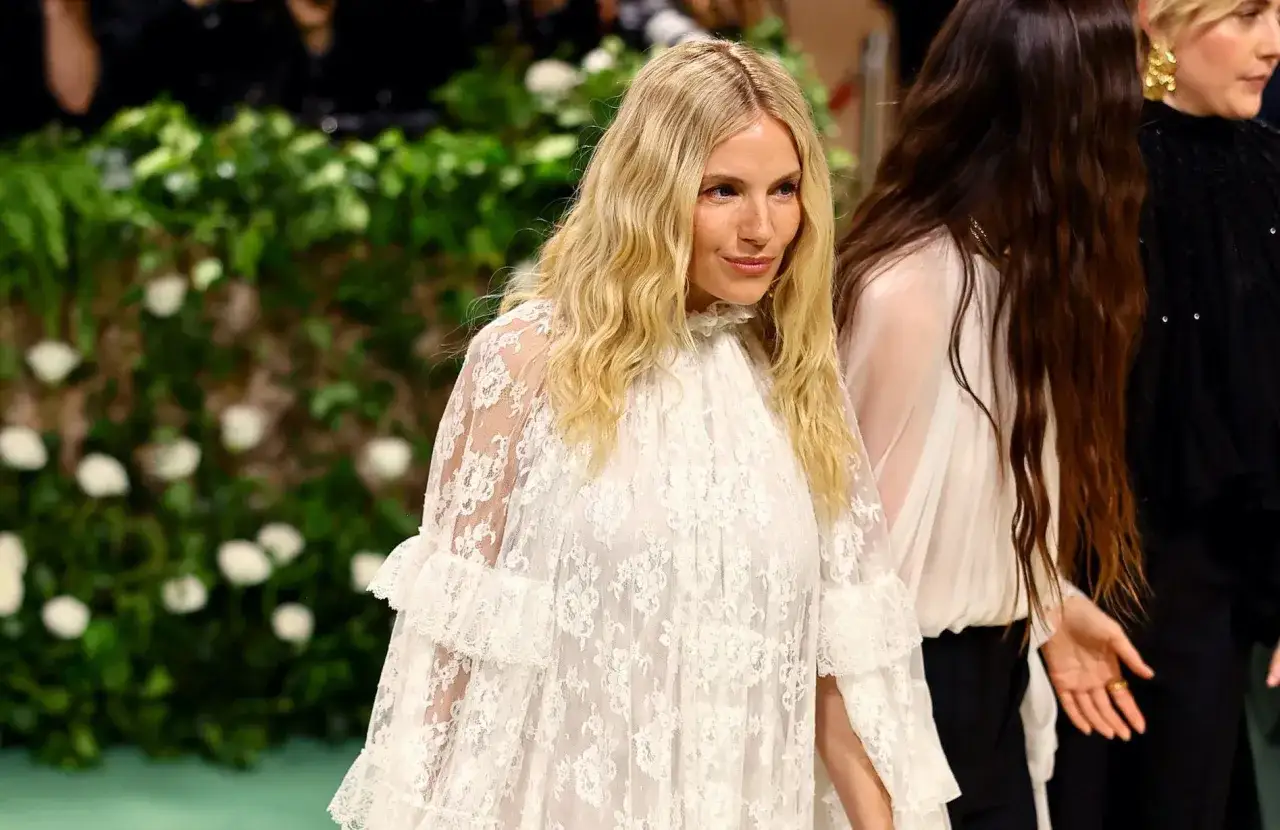 Une femme aux cheveux blonds ondulés, vêtue d'une robe blanche en dentelle, évoque un style bohème chic, parfait pour un festival comme Coachella.