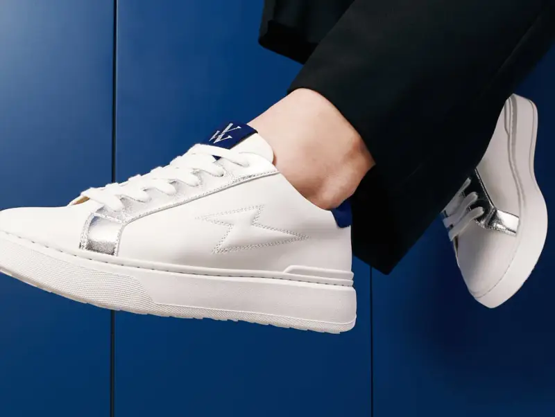 Une tenue chic avec une basket blanche femme, ornée d'éclairs argentés et d'un logo bleu. Parfait pour un look moderne.